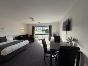 a hotel room with a bed and a desk with a bed and a desk sidx at Mt Cook View Motel - Fox Glacier in Fox Glacier