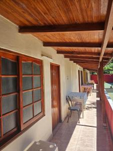 a porch with a table and chairs and a wooden ceiling at peixes apart in Puerto Iguazú