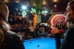 a group of people playing pool in a bar at Butter Hotel in Otari