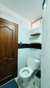 a bathroom with a toilet and a wooden door at Hotel El Altar in Riobamba +40 photos