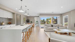 a kitchen and living room with a bar and a couch at Secret Haven in Safety Beach