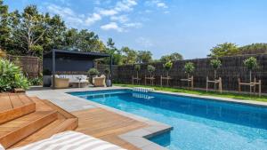 a swimming pool in a backyard with a wooden fence at Secret Haven in Safety Beach