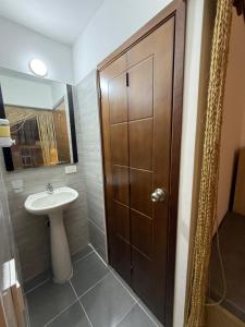 a bathroom with a sink and a wooden door at Hostal Casablanca in San Gil +35 photos