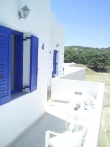 a white room with blue windows and a white chair at Vigles in Adamantas