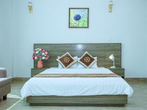 a bedroom with a large bed with white sheets and pillows at Nhà khách Bông Sen in Vinh +12 photos