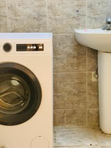 a washing machine in a bathroom with a sink at Rooms & Suites Western Dhafra Housing in Ghayathi