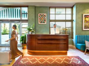 a man and a woman walking around a reception desk at Hotel Trouvail Miami Beach in Miami Beach +38 photos