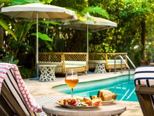 a table with a plate of food and a glass of wine at Hotel Trouvail Miami Beach in Miami Beach