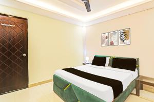 a bedroom with a bed and a wooden door at Super Hotel O Kathauta Jheel Malhaur Gomti Nagar in Lucknow +42 photos