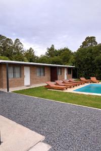 a building with a swimming pool and some chairs at Complejo San Luis in San Luis