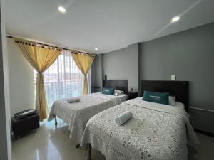 a bedroom with two beds and a window at Ayenda Balcon Real in Tunja +18 photos