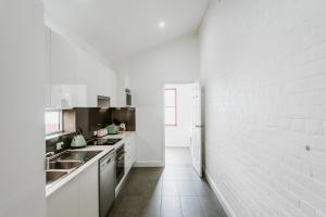 a kitchen with white appliances and a white brick wall at City Sider Motel in Tamworth