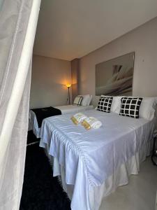 a hotel room with two beds with white sheets at Flat JK 201 in Juazeiro do Norte
