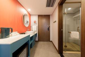 a bathroom with a sink and a shower at 济南璞秀酒店-山东师范大学千佛山店Cultural Experience Hotel in Jinan +58 photos