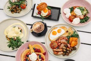a table topped with plates of breakfast foods at Alexandra Hills Hotel in Cleveland +21 photos