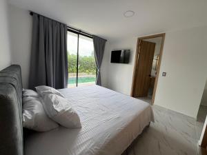 a bedroom with a bed and a large window at Entrebosques in Granada