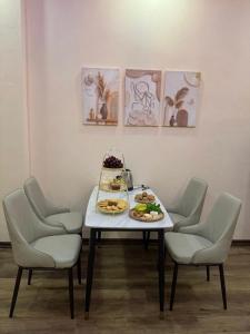 a table with plates of food on it with chairs at Hanoi Amie Duplex Homestay in Hanoi