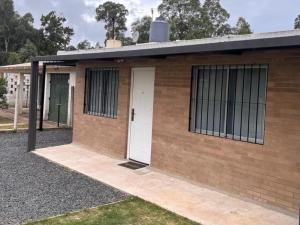 a brick building with a white door and windows at Complejo San Luis in San Luis
