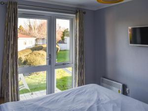 a bedroom with a bed and a large window at Alula Lodge in Lowestoft