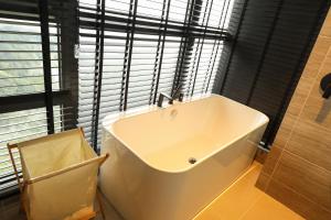 a white bath tub in a bathroom with a window at Antara Genting Cozy Studio in Genting Highlands
