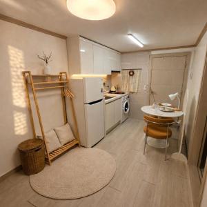 a small kitchen with a table and a white refrigerator at 건대역5분 성수 감성숙소 5 min walk to Konkok Univ Station # 6-Minute Walk to Airport Limousine # Seongsu Cafe Street Walking Tour Hotspots & Pop-up Stores #Seoul Forest # Thukseom Han River Park #KSPO # COEX #Gangnam in Seoul
