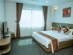 a bedroom with a large bed and a window at Nhà khách Bông Sen in Vinh