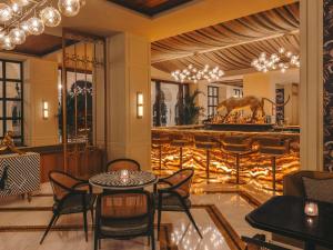a lobby with a table and chairs and a bar at Fairmont Udaipur Palace in Udaipur
