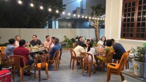 a group of people sitting around a table in a patio at Rose House - Quảng Bình in Bố Trạch