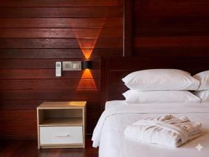 a bedroom with two beds and a wooden wall at Coriana Dive Resort in Waisai +15 photos