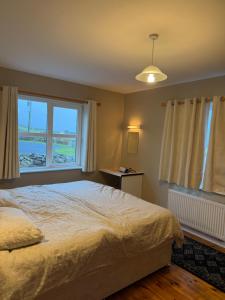 a bedroom with a large bed and a window at Trá Leathan in Doolin