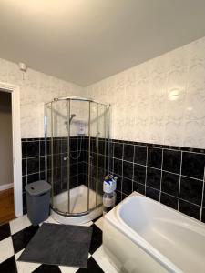 a bathroom with a shower and a bath tub at Trá Leathan in Doolin +27 photos
