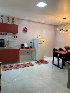 a kitchen with a table and a refrigerator and a table and chairs at Flat JK 201 in Juazeiro do Norte