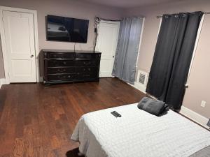 a bedroom with a bed and a dresser with a television at Casa Tabacon CR USA in Trenton
