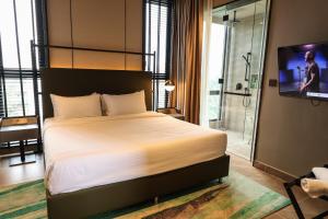 a bedroom with a bed and a tv and a bathroom at Antara Genting Cozy Studio in Genting Highlands