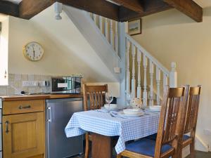 a kitchen with a table with a blue and white table cloth at The Pigsty Cottage E2783 in Oswestry