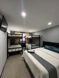 a room with three bunk beds and a television at Ayenda Balcon Real in Tunja