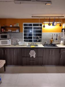 a kitchen with wooden cabinets and a counter top at Posada San Jorge in Pacho