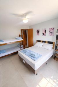 a bedroom with a large bed and a desk at Casa do Sol - 300M da Praia - Ar condicionado in São Pedro da Aldeia +20 photos