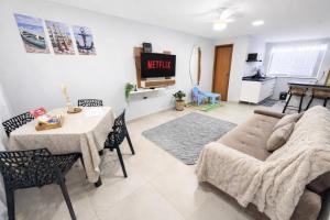a living room with a couch and a table at Casa do Sol - 300M da Praia - Ar condicionado in São Pedro da Aldeia
