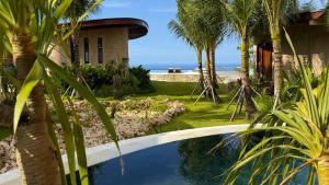 a house with a swimming pool and palm trees at Vanara Resort and Spa in Uluwatu