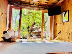 a room with a bed and a large window at Straw hat suites La punta in Santa María Colotepec