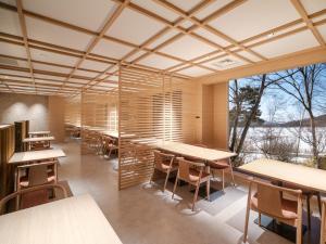 a cafeteria with tables and chairs and a large window at Tateshina Lake Resort in Tateshina