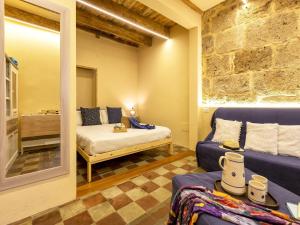 a room with a couch and a bed and a mirror at Monolocale in centro storico in Alghero