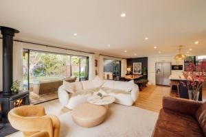 a living room with a white couch and a fireplace at Mokum House Designer Escape with Pool Sauna in Brisbane