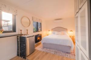 a bedroom with a white bed and a fireplace at Mokum House Designer Escape with Pool Sauna in Brisbane +22 photos