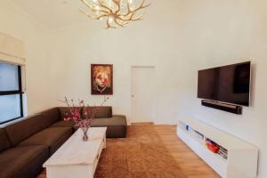 a living room with a couch and a tv at Mokum House Designer Escape with Pool Sauna in Brisbane