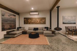 a living room with a couch and a table at Old Bales Serene Hinterland Oasis in Myocum