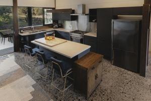 a kitchen with a large island with a counter top at Old Bales Serene Hinterland Oasis in Myocum +16 photos