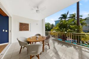 a dining room with a table and chairs on a balcony at Tidal Haven in Noosaville