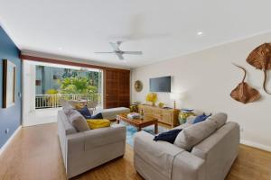a living room with two couches and a table at Tidal Haven in Noosaville